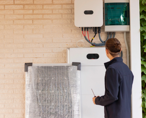 Back view of unrecognizable young man technician installing a solar system for renewable energy